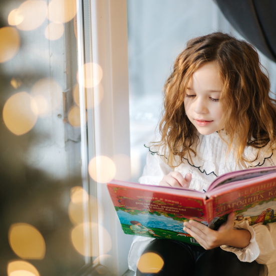 Pige, der læser en stor bog